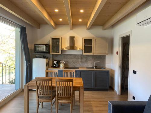 a kitchen with a table and chairs and a refrigerator at Residence Belvedere & Private Beach in Omegna