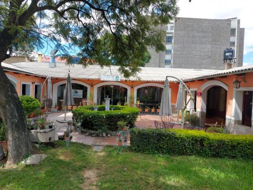 un edificio naranja con parque infantil en un patio en Ñaupa House Hostel, en Cochabamba