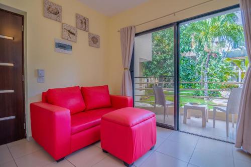 a red couch and a stool in a living room at D'Piero Hotel in Sosúa
