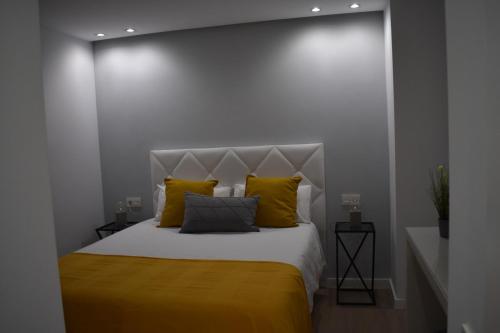 a bedroom with a large bed with yellow pillows at Strada-Beach Las Canteras in Las Palmas de Gran Canaria