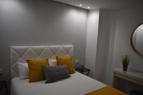 a bedroom with a white bed with yellow pillows at Strada-Beach Las Canteras in Las Palmas de Gran Canaria