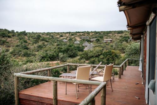 a wooden deck with chairs and a table on it at Bukela Game Lodge - Amakhala Game Reserve in Amakhala Game Reserve
