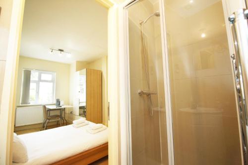 a bathroom with a shower and a bed in a room at Flexistay Tooting Studios in London