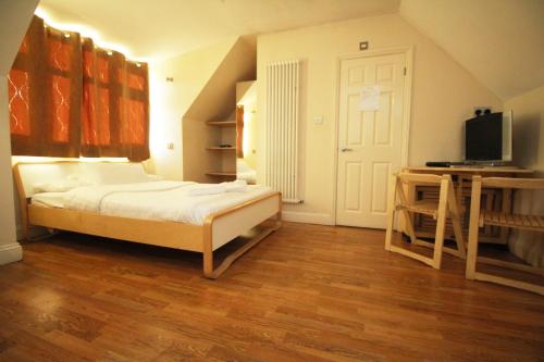 ein Schlafzimmer mit einem Bett und einem TV in einem Zimmer in der Unterkunft Flexistay Tooting Studios in London