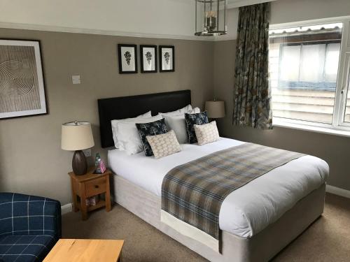a bedroom with a large bed and a window at Oak Tree Lodge & Holiday Parking in Burstow