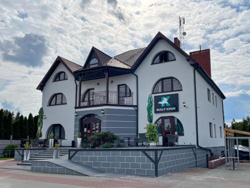 un gran edificio blanco con un cartel. en Restauracja Biały Kruk, en Górno