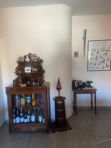 a room with a shelf of bottles and a table at SAUZE COMODO PISTA CLOTES, CENTRALE CON PARKING in Sauze dʼOulx