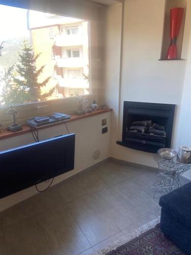 a living room with a television and a fireplace at SAUZE COMODO PISTA CLOTES, CENTRALE CON PARKING in Sauze dʼOulx