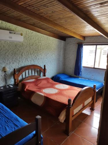 a room with two beds and a table in it at Casa BELLAGIO in Barra del Chuy