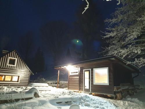 a cabin in the snow at night with a light at horská chata Cecilie in Olešnice v Orlických horách