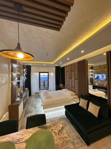 um quarto com uma cama, um sofá e uma mesa em Apartmani Fashion -Milmari Resort em Kopaonik