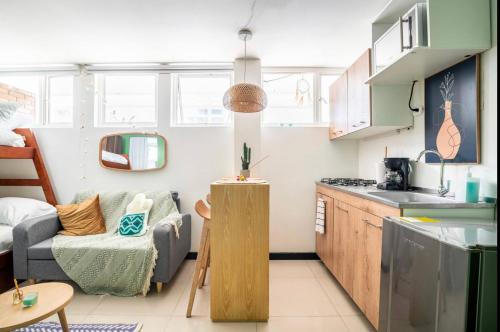 cocina pequeña y sala de estar con sofá en Mukuba Homes, en Bogotá
