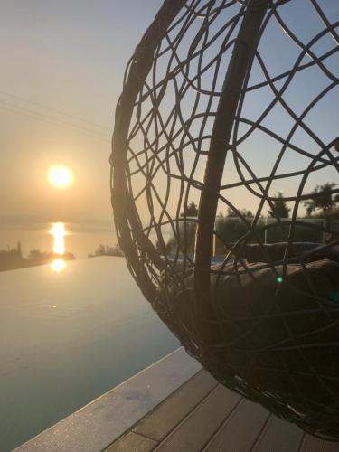 a metal ball on a dock with the sunset in the background at ANATOLI VILLAS in Nikiana