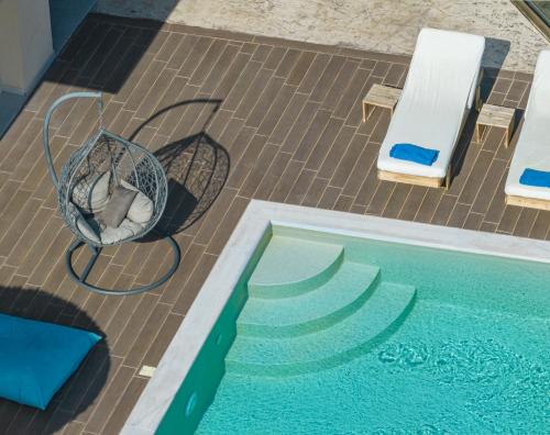 a dog laying in a basket next to a swimming pool at ANATOLI VILLAS in Nikiana