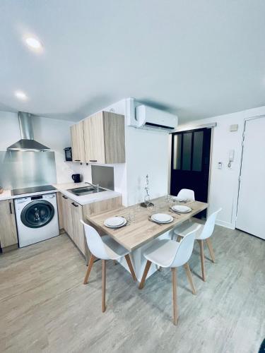 - une cuisine avec une table en bois et des chaises blanches dans l'établissement * Villa Adélaïde * Opéra *, à Vichy