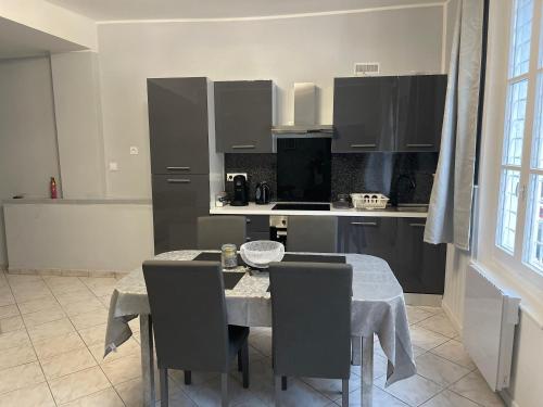 une cuisine avec une table et des chaises ainsi qu'une cuisine avec une table et des chaises dans l'établissement Appartement hyper centre, à Chalon-sur-Saône