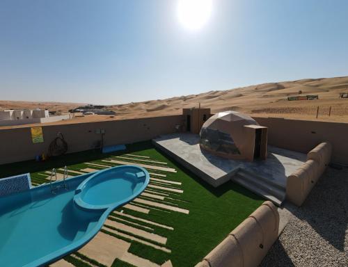 a resort with a swimming pool in the desert at Sand House ساند هاوس in Al Raka
