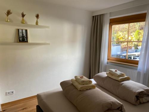 Dos camas en una habitación con toallas. en Gemütliche Wohnung mit Gartenblick en Innsbruck