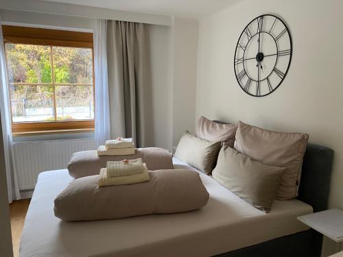 a couch in a living room with a clock on the wall at Gemütliche Wohnung mit Gartenblick in Innsbruck