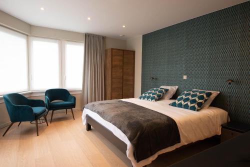 um quarto com uma cama grande e 2 cadeiras em B&B Maaltebrug em Gent