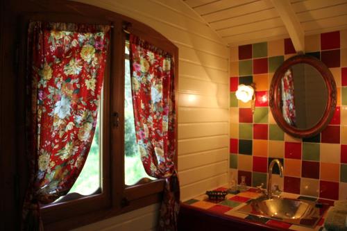 ein Bad mit einem Waschbecken und einem Fenster in der Unterkunft La Hulotte in Mazamet