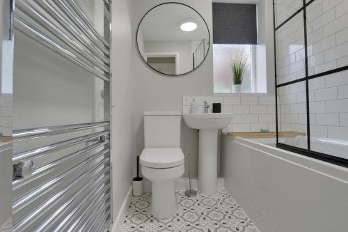 a bathroom with a toilet and a sink and a mirror at Springvale in Sheffield