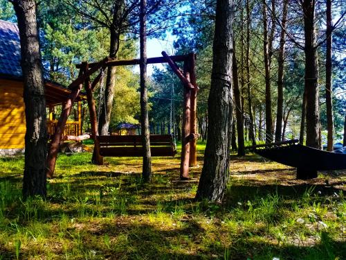 a swing set in a park with trees at Ostoja Stacze in Stacze