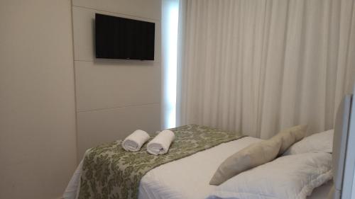 a bedroom with a bed with two pillows and a television at Apart Hotel Vista Azul - hospedagem nas montanhas in Domingos Martins