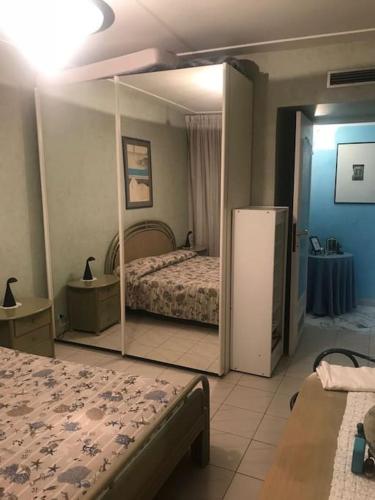 - une chambre avec un lit et un réfrigérateur dans l'établissement APPARTAMENTO GRANDE E COMODO, TERRAZZO VISTA MARE, à Menton