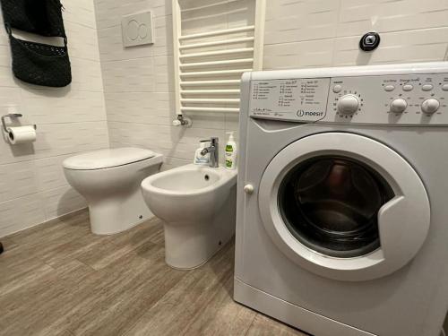a bathroom with a washing machine and a toilet at WelcHome Marghera 18 in Milan