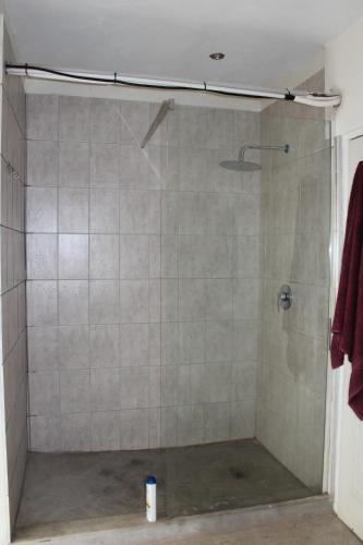 La salle de bains est pourvue d'une douche avec une porte en verre. dans l'établissement Marloth Park, Kruger safari house - solar, à Marloth Park