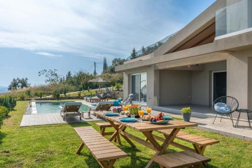 a backyard with a picnic table and a pool at ANATOLI VILLAS in Nikiana