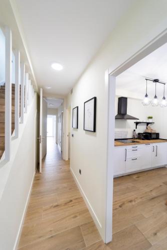 an open hallway with white walls and a kitchen with wood floors at Apartamentos San Lazaro in Santiago de Compostela