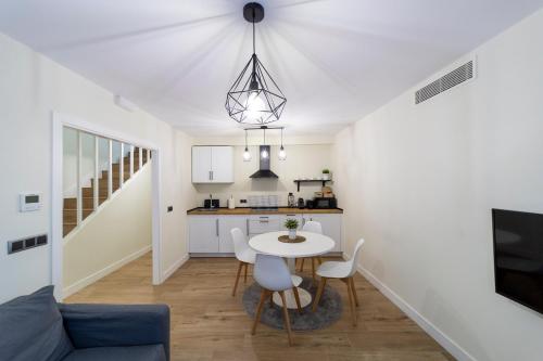 cocina y comedor con mesa y sillas en Apartamentos San Lazaro en Santiago de Compostela