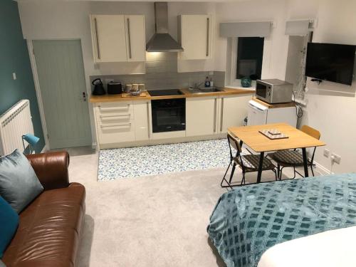 a kitchen with a couch and a table in a room at Hideaway between Coast and Moors in a beautiful Village apartment in Sleights