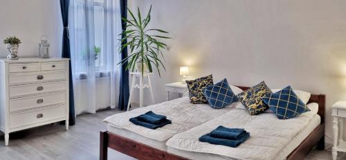 ein Schlafzimmer mit einem Bett mit blauen Kissen in der Unterkunft Apartament Kaczyniec 10 in Gliwice