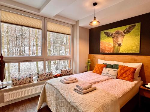 a bedroom with a bed with a deer painting on the wall at Apartament SPA 04 Resort Kozubnik blisko Szczyrk - 5D Apartamenty in Porąbka