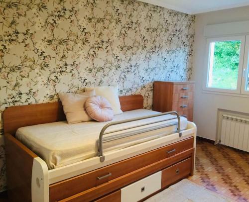 um quarto com uma cama com uma cómoda e uma parede em Disfruta de la naturaleza en el centro de Asturias em Siero
