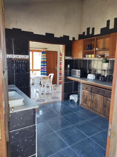 a kitchen with blue tiles on the floor and a table at Casa Palazzo in Barra del Chuy