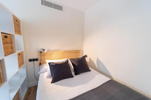a bedroom with a bed with two pillows on it at Apartamentos San Lazaro in Santiago de Compostela
