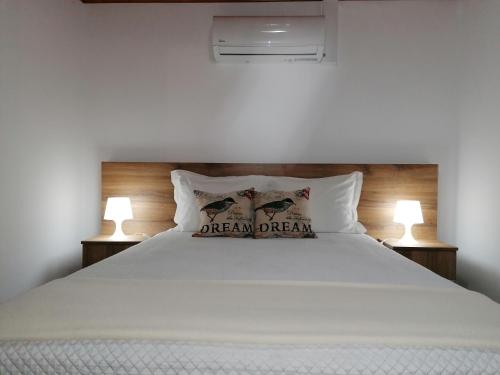 ein Schlafzimmer mit einem Bett mit zwei Kissen darauf in der Unterkunft A Casa da Formosinha in Madalena