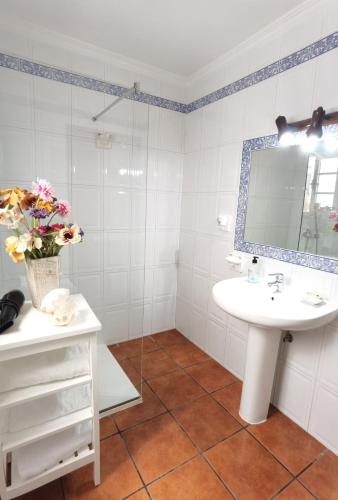 a white bathroom with a sink and a mirror at apartamentoscasajulia in La Santa