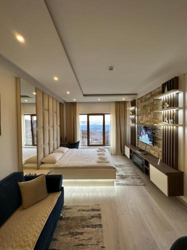 een slaapkamer met een groot bed en een groot raam bij Apartman Holiday in Kopaonik
