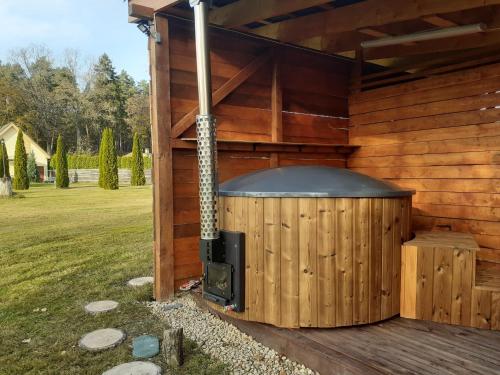 a wooden building with an outdoor fireplace on a deck at Forest Edge Lodge in Rīga