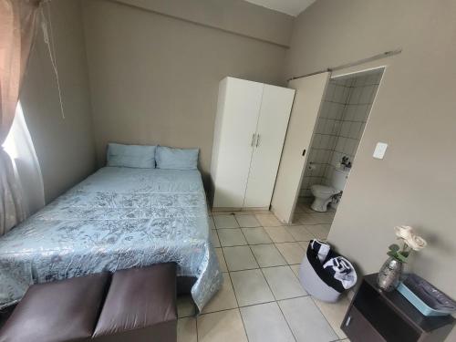 - une petite chambre avec un lit et une salle de bains dans l'établissement The Westpoint -Modern ,secure apartment, à Roodepoort