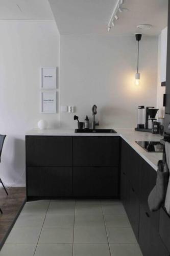 a kitchen with a black and white counter top at Lovely two room unit with free parking in Kuopio