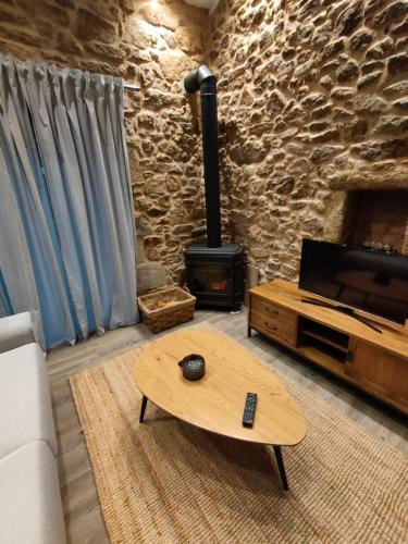 a living room with a fireplace and a coffee table at Casa María da Retratista in Muxia