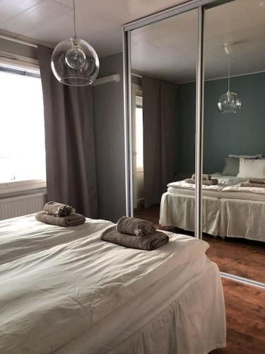 a bedroom with two beds and a large mirror at Lovely two room unit with free parking in Kuopio