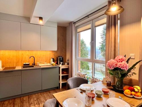 a kitchen with a table and a dining room at Apartament SPA 04 Resort Kozubnik blisko Szczyrk - 5D Apartamenty in Porąbka