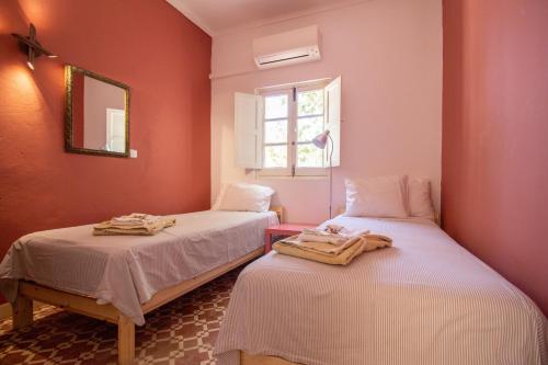 two beds in a room with red walls at Lovely Rustic Casa Catita with amazing roof terrace views in Tavira
